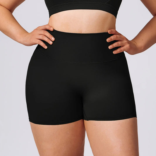 Plus-size woman wearing high-waisted performance training shorts during workout
