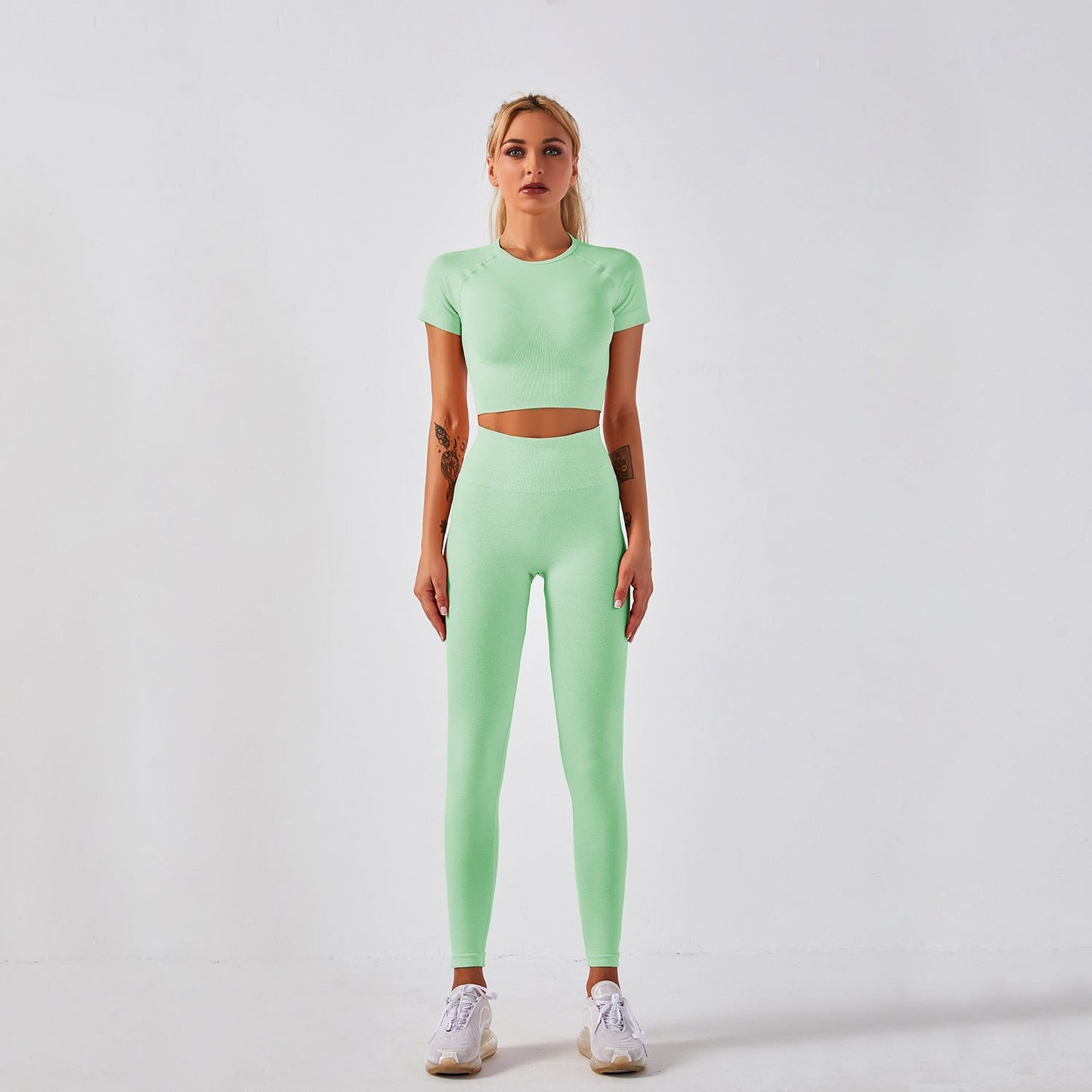 Women's seamless yoga set with short-sleeve top & trousers, in breathable nylon-spandex. Solid colors: hemp grey, pink, sky blue, orange, green, purple & red. By TNT Fitness Gear. Perfect for workouts