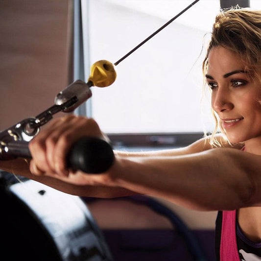 A woman using the cable machine attachment set with tricep rope and row handles by TNT Fitness Gear in a gym setting