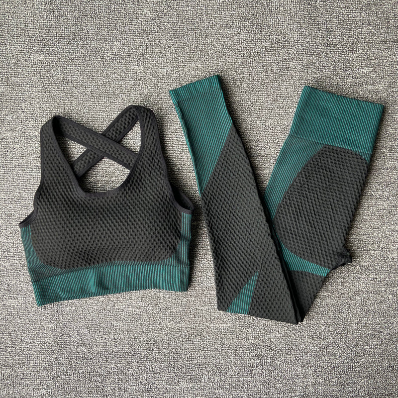Woman wearing black and green long sleeve gym top and leggings