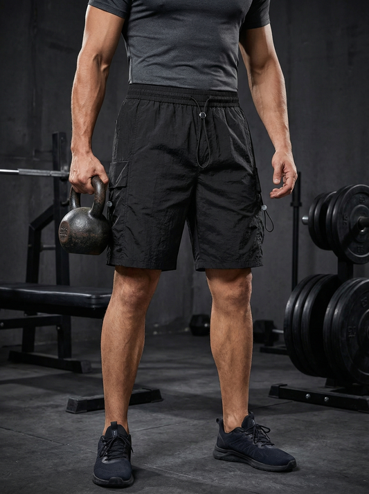 Person holding a kettlebell in a gym setting, wearing black athletic workout shorts lightweight design