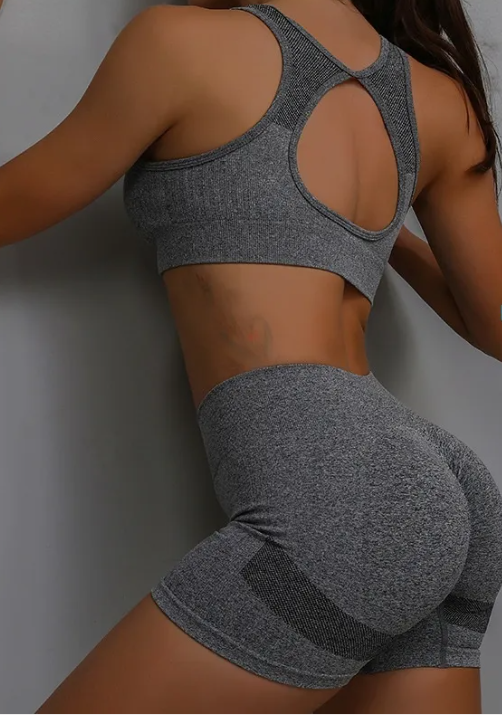 A person wearing a two-piece training shorts set against a gray background