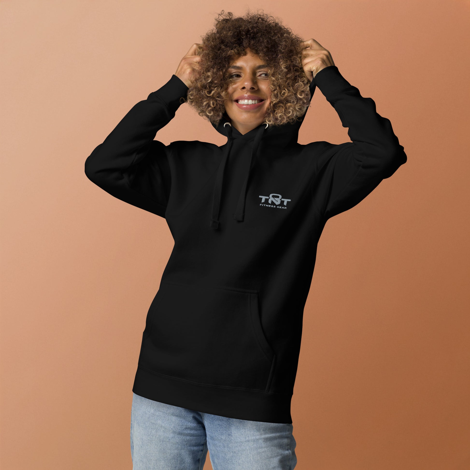 Black unisex TNT Fitness Gear hoodie with minimalist chest logo, front pouch pocket, and athletic fit for gym and lifestyle wear.